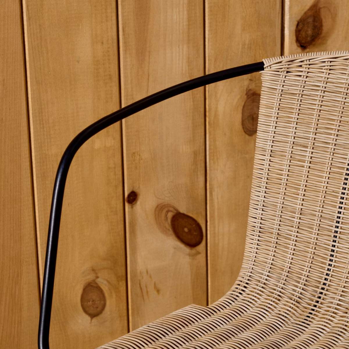 Kave Home Eltiera stackable chair in synthetic rattan with black steel frame and armrests