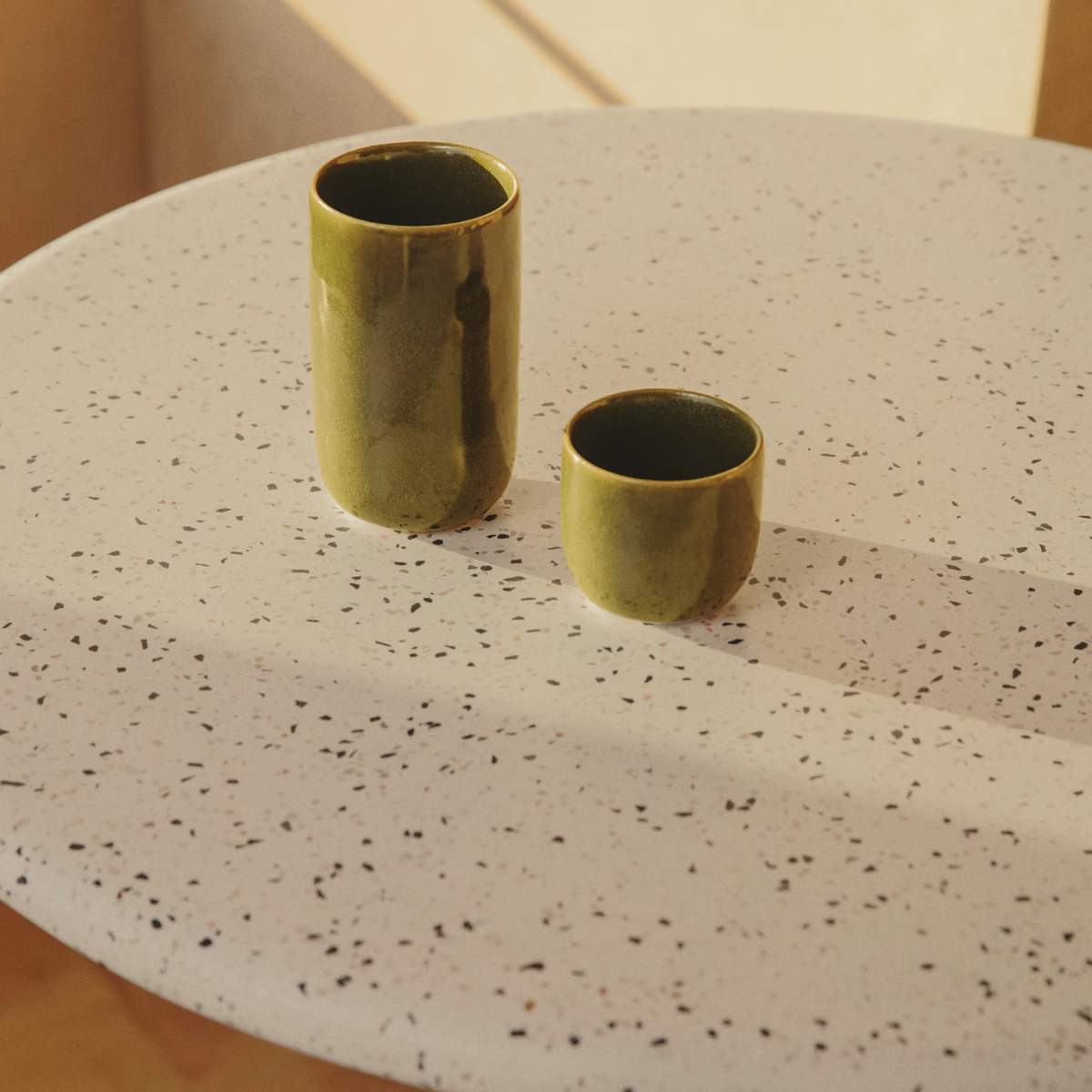 Kave Home Saura round high bar table made of black metal with a white terrazzo top, 96 x Ø70 cm
