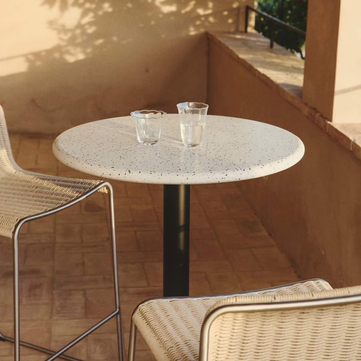 Kave Home Saura round high bar table made of black metal with a white terrazzo top, 96 x Ø70 cm